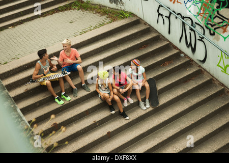 Draufsicht der Kindergruppe sitzt auf der Treppe im Freien, Deutschland Stockfoto