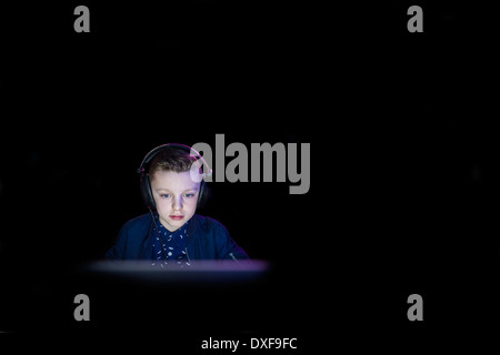 Ein kleiner Junge auf einem Computerspiel konzentrieren. Stockfoto