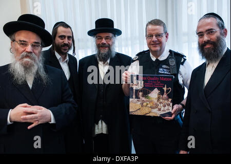 London, UK - 25. März 2014: stellvertretender Polizeipräsident Simon Byrne (2. von rechts) erhält handgemachte Matzen von Mitgliedern der jüdischen Gemeinschaft von Stamford Hill vor Pessach. Matzen-Credit: Piero Cruciatti/Alamy Live-Nachrichten Stockfoto