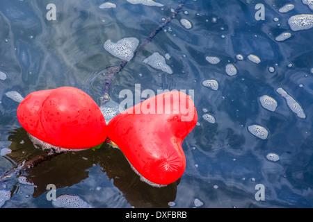 Liebe ist Weg - zwei herzförmige Luftballons in das Wasser fließt. Stockfoto