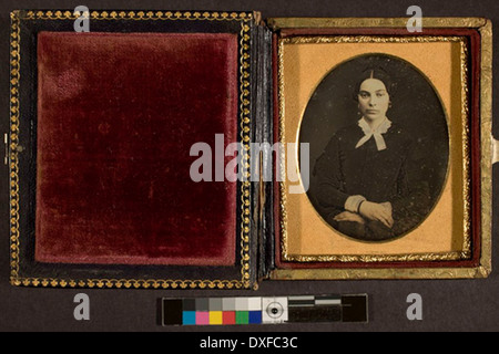 Dieses Vintage-Porträt zeigt eine nicht identifizierte Frau, die in einem Moment aus der Vergangenheit aufgenommen wurde. Das Foto zeigt die Mode und den sozialen Stil der Epoche. Stockfoto