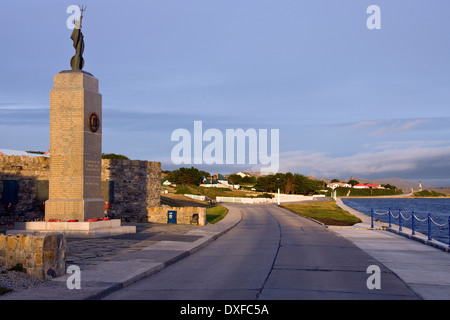 Die Falkland-Inseln War Memorial mit Government House im Hintergrund - Port Stanley auf den Falklandinseln (Islas Malvinas). Stockfoto