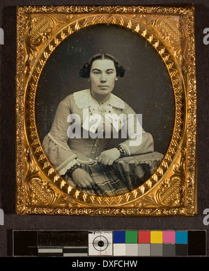 Dieses Porträt zeigt eine nicht identifizierte Frau aus der Vergangenheit, aufgenommen in einem Vintage-Foto. Das Bild spiegelt die Mode und den Stil dieser Zeit wider und bietet einen Einblick in einen Moment der Geschichte durch die Linse früherer Fotografie. Stockfoto