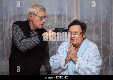 Wütender senior Mann eine Waffe auf ältere Frau. Stockfoto