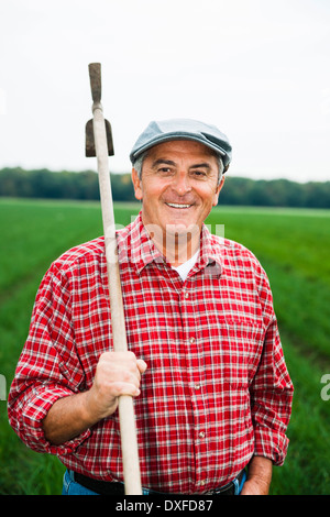 Porträt der Bauer im Feld hält eine Spitzhacke, Hessen, Deutschland Stockfoto