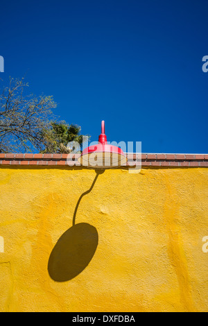 Die lebendigen Farben der eine leuchtend gelbe Wand rot altmodischen Straßenlaterne erstellen ein sehr buntes Stillleben in Tucson, Arizona. Stockfoto