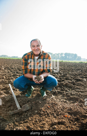 Porträt von Landwirt Boden in den Händen halten und Blick in die Kamera, Deutschland Stockfoto