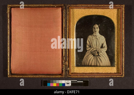 Dieses Vintage-Foto zeigt eine nicht identifizierte junge Frau, die aus einer vergangenen Zeit aufgenommen wurde. Das Foto spiegelt den Mode- und Porträtstil der damaligen Zeit wider. Stockfoto