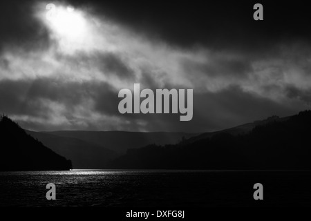 Sonne bricht durch Wolke über Caban Coch Damm. Stockfoto