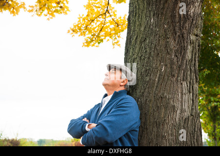 Portrait of Senior Man lehnte sich gegen Baum, Mannheim, Baden-Württemberg, Deutschland Stockfoto