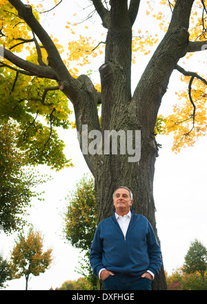 Portrait of Senior Man lehnte sich gegen Baum, Mannheim, Baden-Württemberg, Deutschland Stockfoto