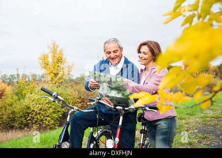 Paar mit Fahrrädern Blick auf Karte im Herbst, Mannheim, Baden-Württemberg, Deutschland Stockfoto