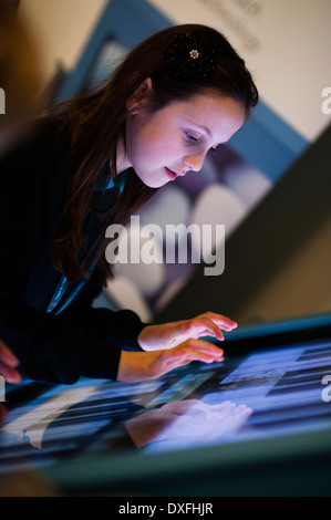 Musikerziehung: Eine Grundschule Mädchen Kind Musizieren mit großen Bildschirm Touch sensible Computer in Klasse Lektion Unterricht,, Wales UK Stockfoto