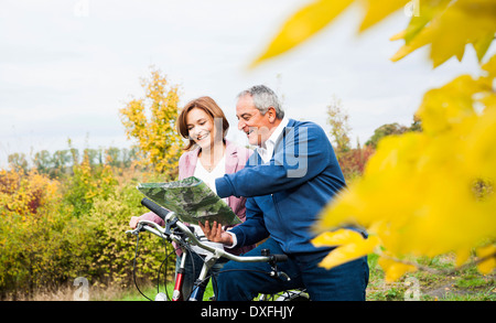 Paar mit Fahrrädern Blick auf Karte im Herbst, Mannheim, Baden-Württemberg, Deutschland Stockfoto