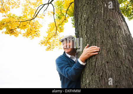 Ältere Mann hinter dem Baum, Mannheim, Baden-Württemberg, Deutschland Stockfoto