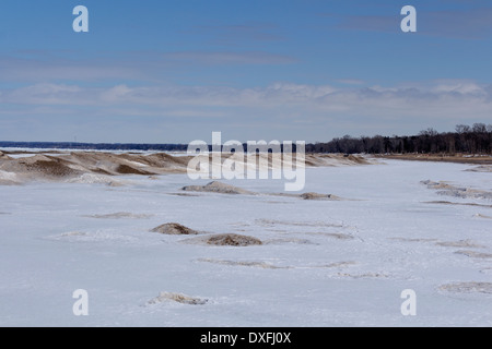 Sand abgedeckt Schneeverwehungen entlang der Ufer des Lake Huron in Grand Bend Ontario. Stockfoto