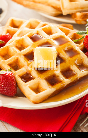 Hausgemachte Waffeln mit Erdbeeren und Ahornsirup Stockfoto