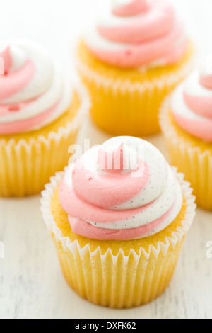 Vanille Cupcakes mit Erdbeer-Sahne gekrönt. Stockfoto