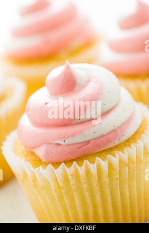 Vanille Cupcakes mit Erdbeer-Sahne gekrönt. Stockfoto