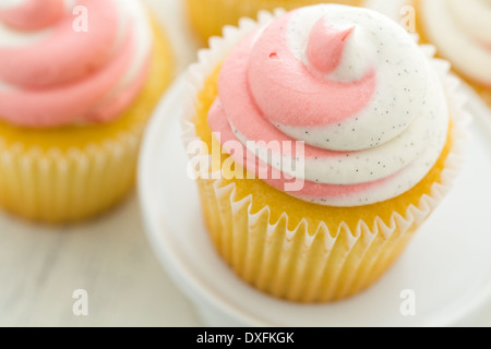 Vanille Cupcakes mit Erdbeer-Sahne gekrönt. Stockfoto