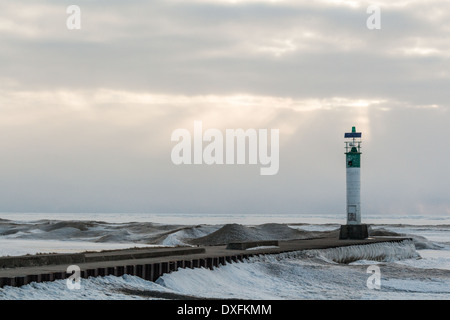 Grand Bend, Ontario. Leuchtturm am Ende der Pier als die Sonnenuntergänge über eine gefrorene Lake Huron. Stockfoto