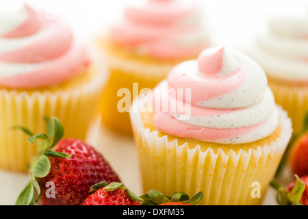 Vanille Cupcakes mit Erdbeer-Sahne gekrönt. Stockfoto