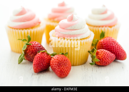 Vanille Cupcakes mit Erdbeer-Sahne gekrönt. Stockfoto
