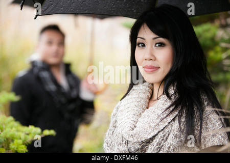 Close-up Portrait Frau unter Dach mit Mann im Hintergrund, Ontario, Kanada Stockfoto