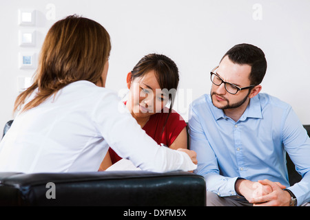 Rückansicht der Geschäftsfrau im Gespräch mit jungen Paar, Deutschland Stockfoto