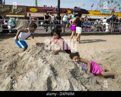 Kinder spielen im Sand am Tag des 23. jährliche Coney Island Bildhauerei Burg Wettbewerbs in Brooklyn, NY, 2013. Stockfoto