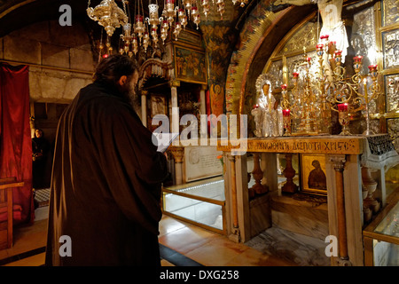 Griechisch-orthodoxen Priester im Rahmen einer Masse Prozession vor dem Altar der Kreuzigung auf der linken Seite der Kalvarienberg oder Golgatha traditionell als Ort der Kreuzigung Jesu betrachtet. Der Hauptaltar gehört der griechisch-orthodoxen, der den Fels von Golgatha 12. Station des Kreuzes enthält im Inneren der Kirche des Heiligen Grabes christlichen Viertel Altstadt Ost Jerusalem Israel Stockfoto