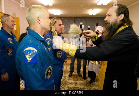 Ein russisch-orthodoxer Priester segnet Expedition 39 Astronaut Steve Swanson der NASA im Kosmonauten Hotel vor seiner Markteinführung auf der Sojus-Rakete zur internationalen Raumstation ISS 25. März 2014 in Baikonur, Kasachstan. Start der Sojus-Rakete schicken Expedition 39 Sojus Kommandant Alexander Skworzow der russischen Federal Space Agency, Astronaut Steven Swanson der NASA, Kosmonaut Oleg Artemyev von Roskosmos auf einer sechsmonatigen Mission an Bord der internationalen Raumstation ISS. Stockfoto