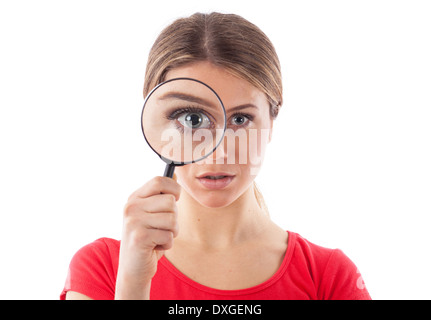 Schöne Frau, die durch ein Vergrößerungsglas, isoliert auf weiss Stockfoto