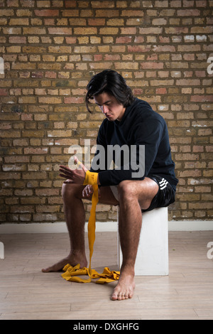 Junge malaysische Boxer tragen Hoodie und Gurte um die Hände wickeln Stockfoto