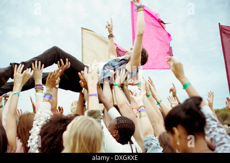 Mann Crowdsurfing beim Musikfestival Stockfoto