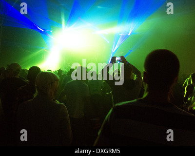 Silhouette der Menschenmenge mit Blick auf beleuchtete Bühne beim Musikfestival Stockfoto