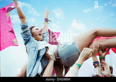 Begeisterte Frau Crowdsurfing beim Musikfestival Stockfoto