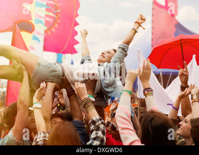 Frau Crowdsurfing beim Musikfestival Stockfoto