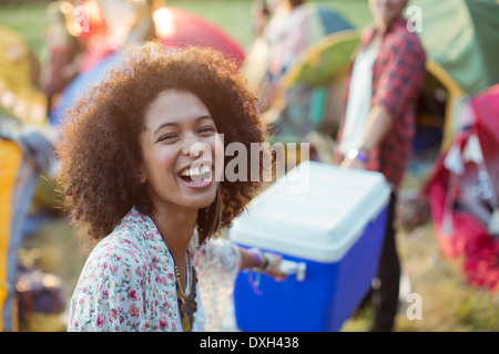 Porträt der lachende Frau helfen Mann tragen kühler draußen Zelte beim Musikfestival Stockfoto