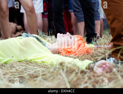 Frau in Perücke Verlegung mit ausgestreckten Gras beim Musikfestival Stockfoto