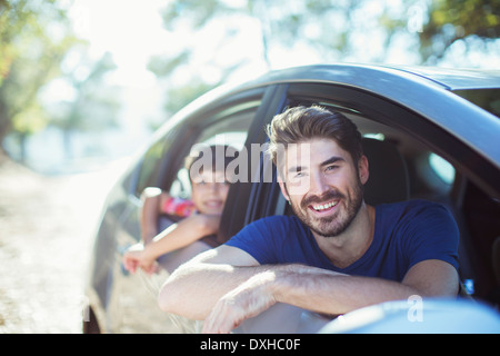 Porträt des Lächelns, Vater und Sohn gelehnt, Autoscheiben Stockfoto