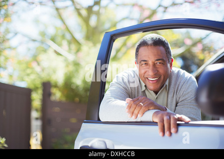 Portrait von zuversichtlich senior Mann lehnte sich gegen Autotür Stockfoto