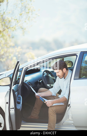 Mann im Auto auf Karte suchen Stockfoto