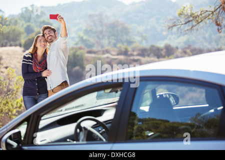 Paar Einnahme Selbstbildnis mit Handy außerhalb Auto Stockfoto