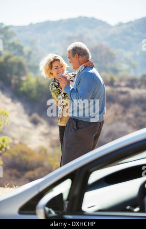 Gerne älteres Paar am Straßenrand außerhalb Auto tanzen Stockfoto