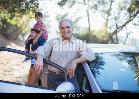 Portrait von senior Mann stützte sich auf Auto Stockfoto