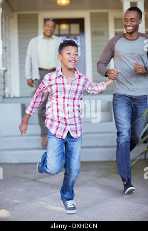 Vater und Sohn Hand in Hand und läuft vor Haus Stockfoto