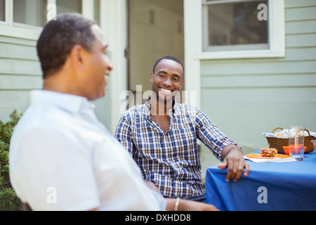 Vater und Sohn bei Terrassentisch Stockfoto