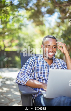 Glücklicher Mann mit Laptop im freien Stockfoto