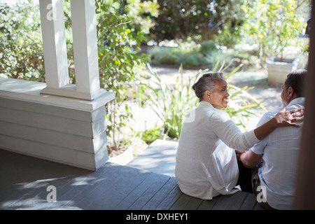 Älteres paar umarmt auf Veranda Stockfoto